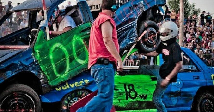 Action-packed demolition derby cars colliding outdoors at county fair