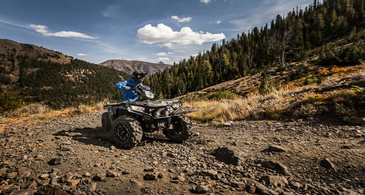 All-terrain vehicle navigating rocky high country trail scenery