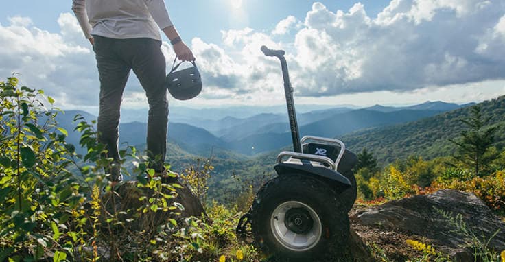 Rider on Segway overlooking alpine mountain valley in Alaska