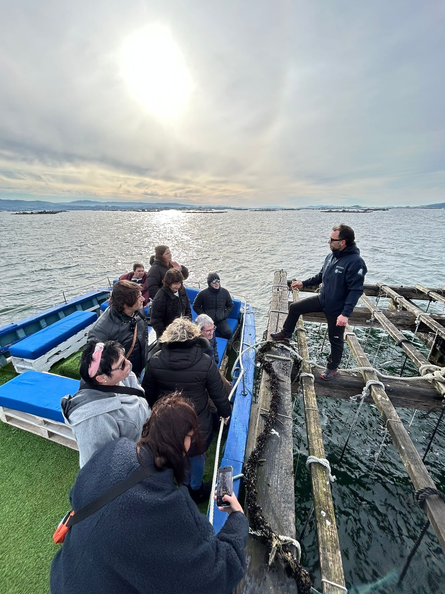 Passengers seated on small boat under bright midday sun