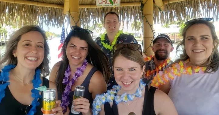 Group of friends on tiki cruise wearing leis and drinks