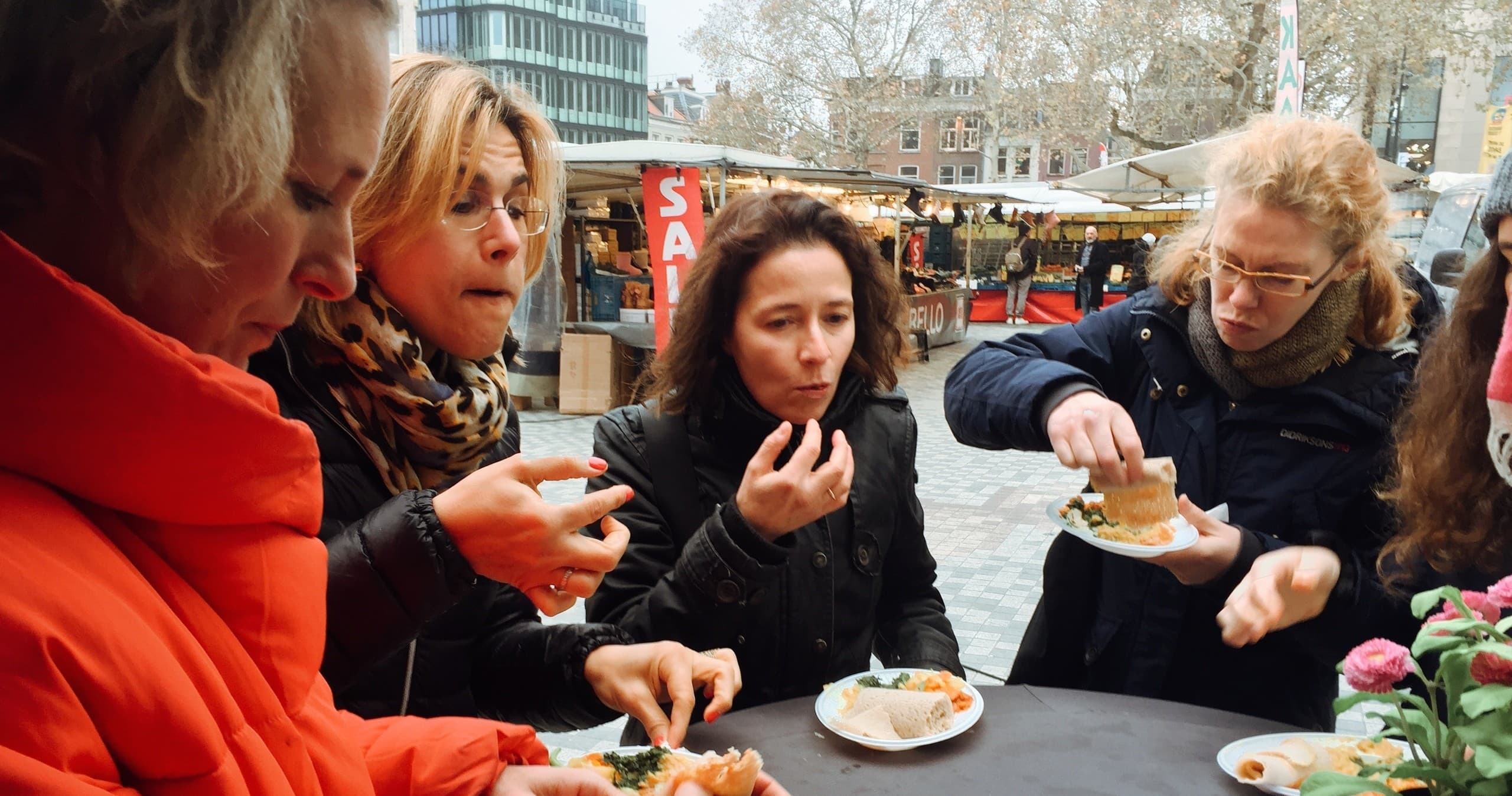 People sampling street food outdoors at Utrecht market tour