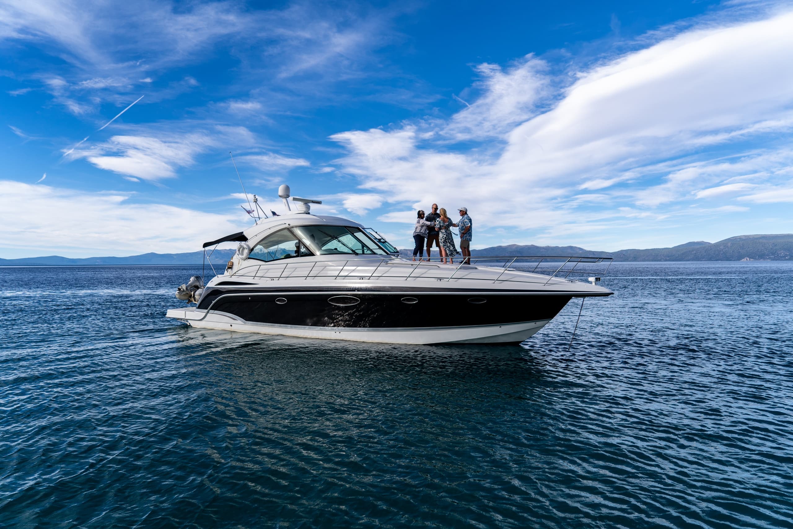 Friends on luxury boat under blue sky on scenic lake Tahoe