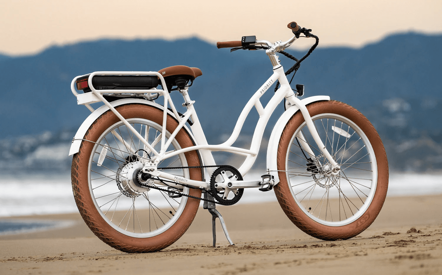 Electric beach cruiser bicycle parked on sandy shoreline