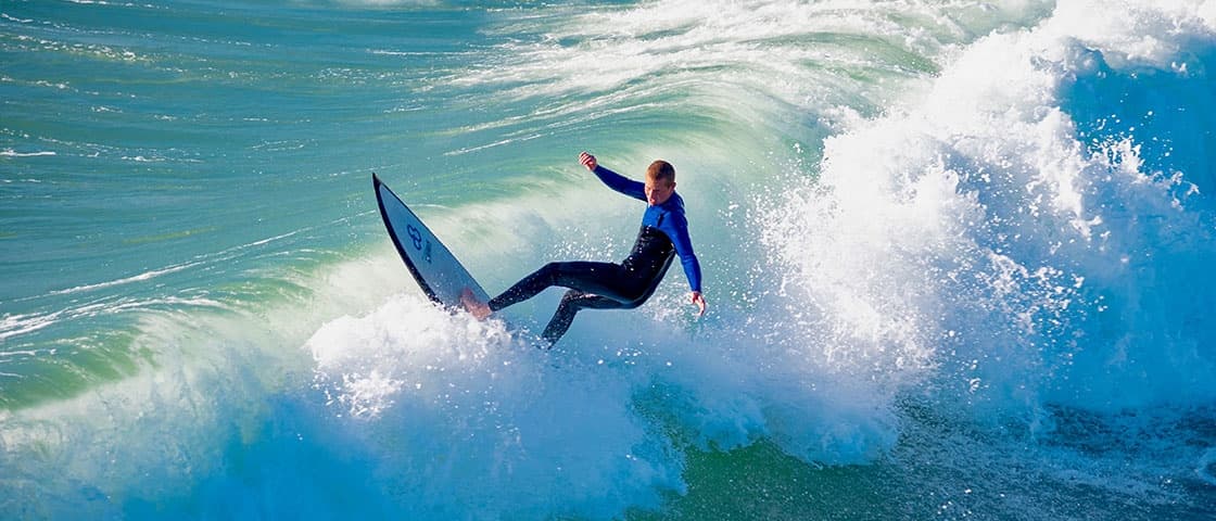 Surfer carving through turquoise wave in ocean surf action