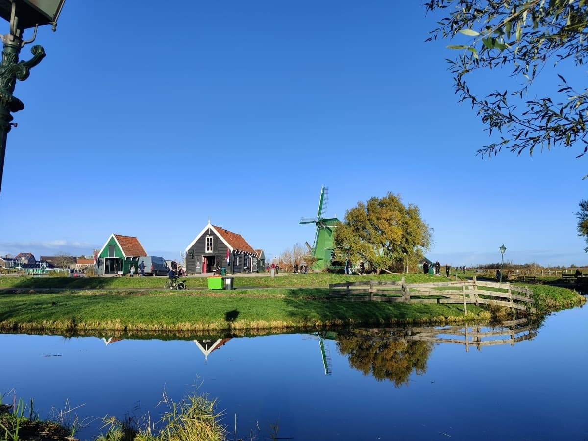 Windmill and farmhouses reflected in Dutch canal, Zaanse Schans