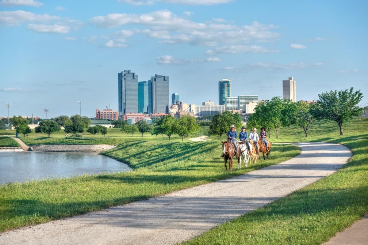 Horseback riders along Trinity River trail near Fort Worth skyline