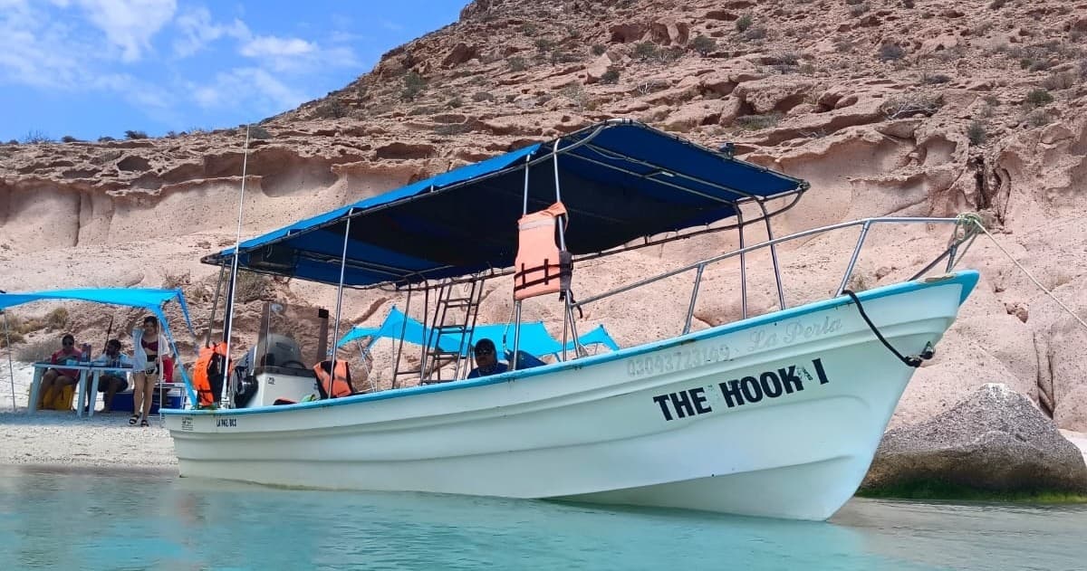 Tour boat THE HOOK moored in La Paz turquoise cove