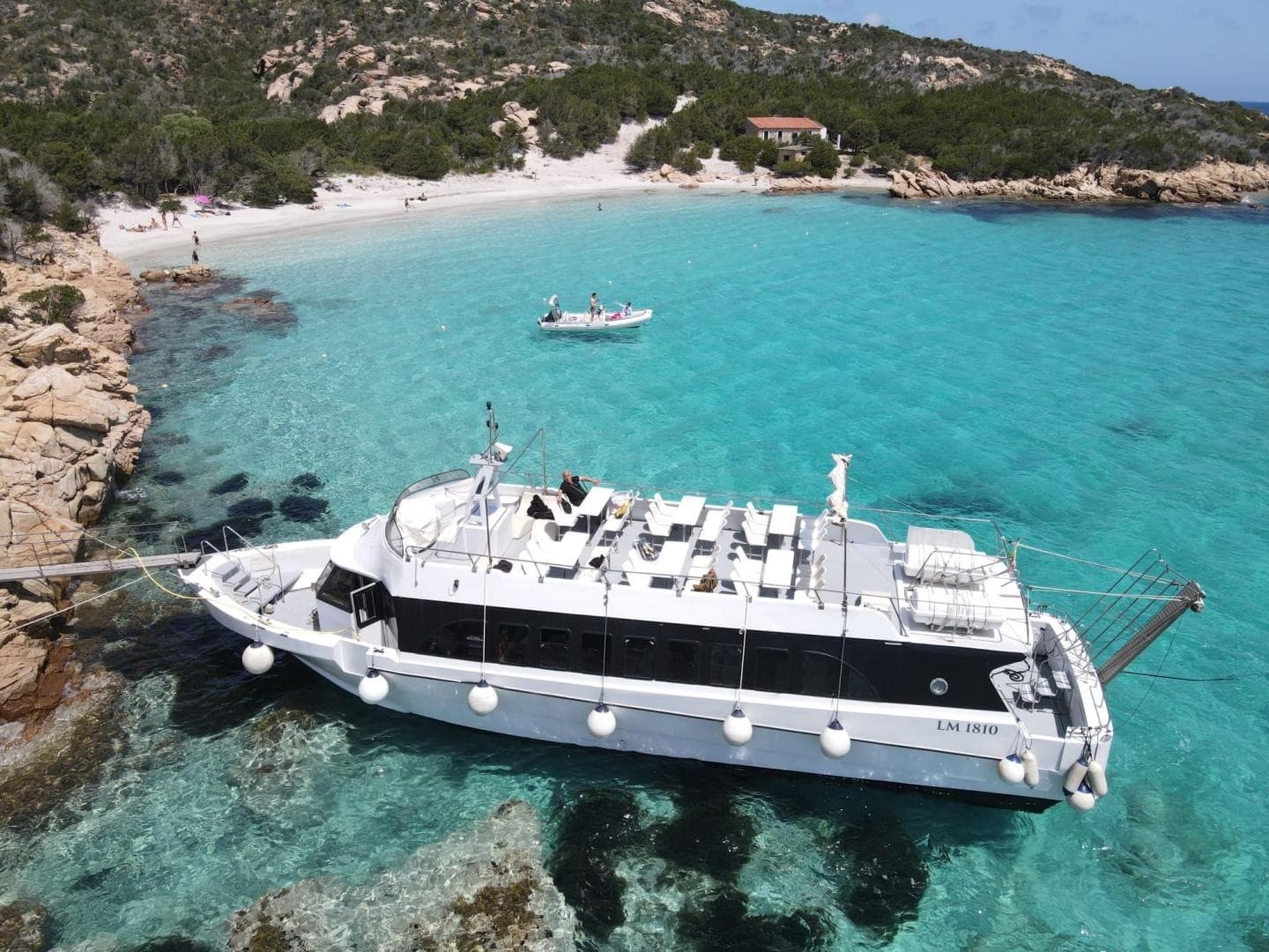 Aerial tour boat anchored in turquoise Mediterranean bay