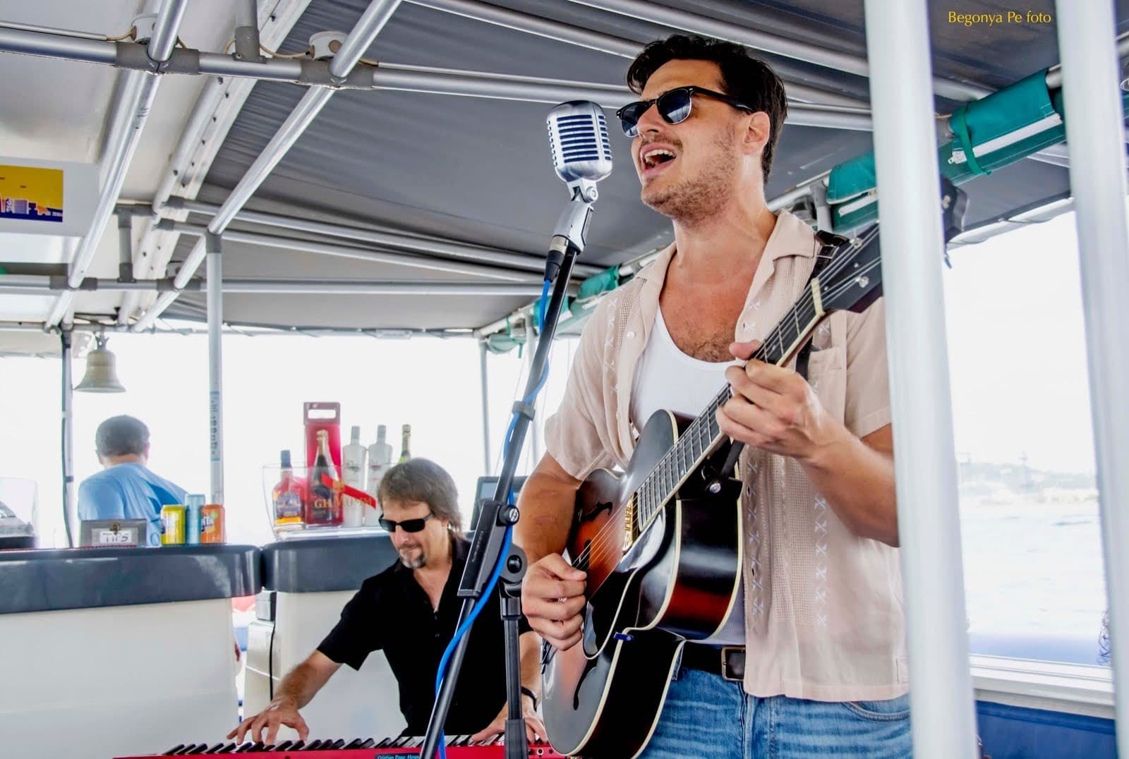 Live acoustic duo performing on deck during scenic Barcelona harbor cruise