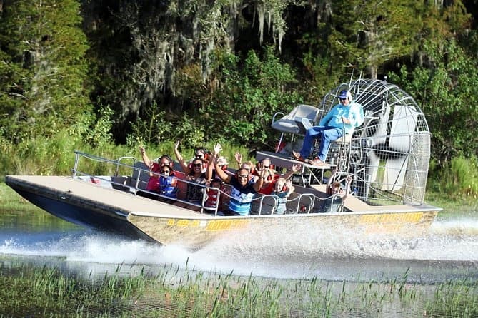 Airboat ride speeding through wetland grasses with sightseeing group