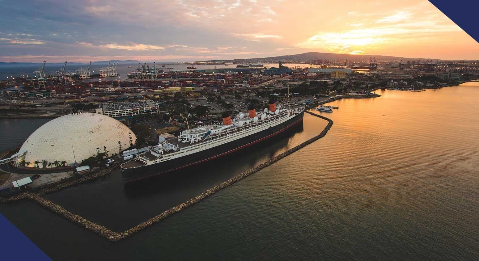 Aerial helicopter view of harbor, cruise ship and waterfront at sunset