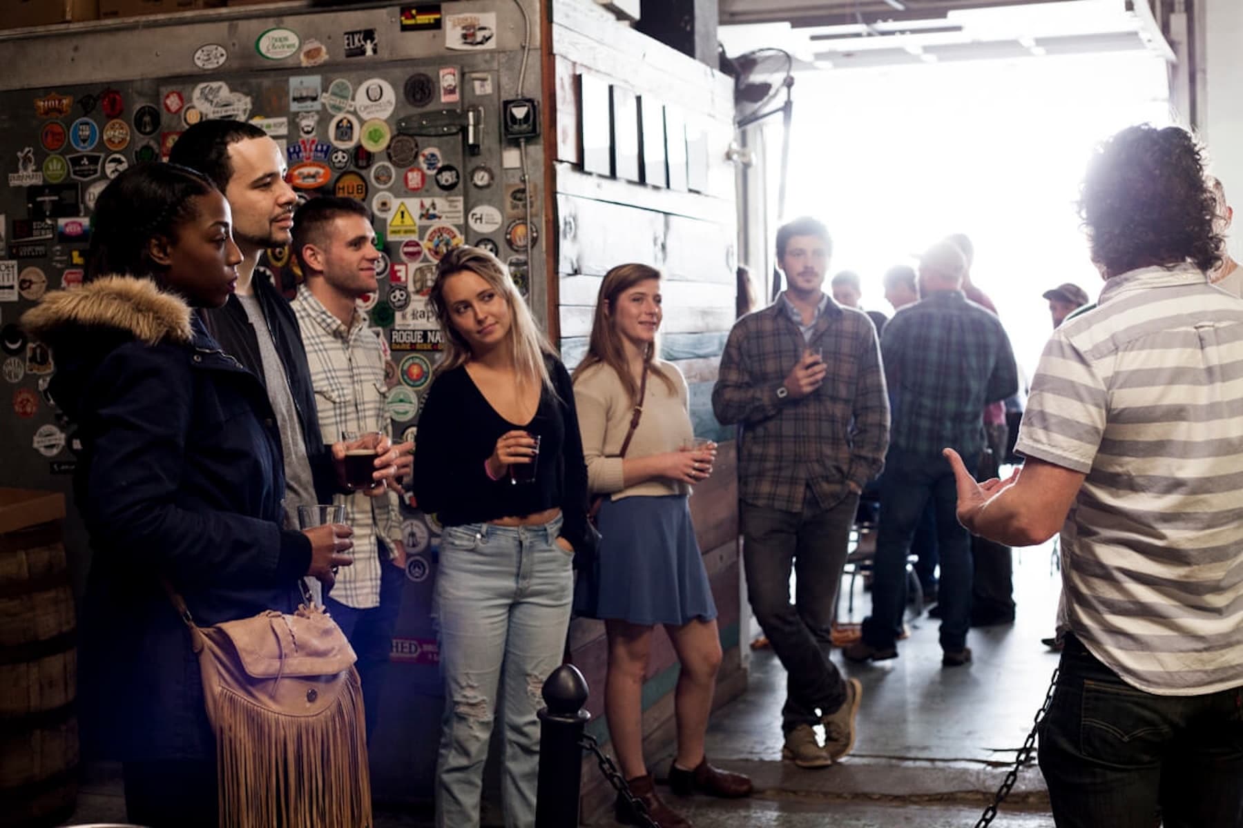 Brewery tour group listening to guide inside taproom experience