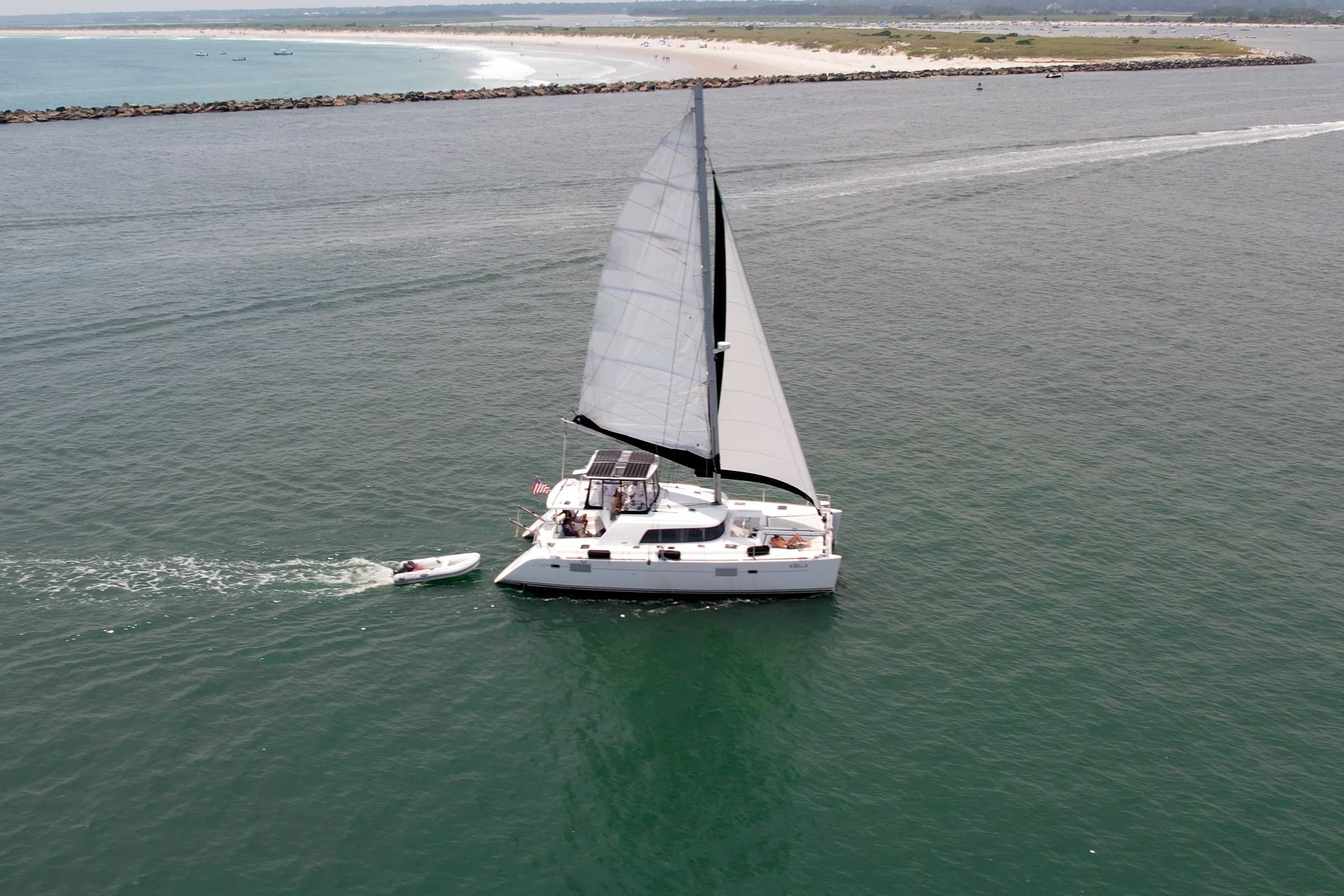 Aerial view of sailboat near sandy shore and marshland coast