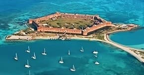Aerial view of island fort with sailboats in turquoise waters
