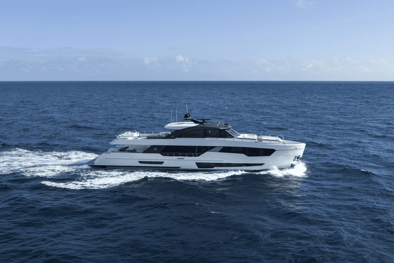 Sleek expedition yacht cutting through deep blue open ocean water