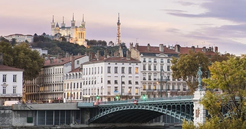 River bridge and city skyline at dusk, scenic urban waterfront view
