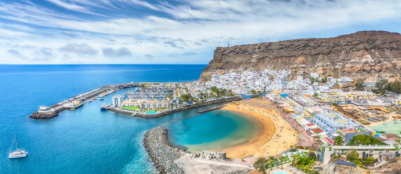 Aerial coastal town and harbor panorama with sandy bay view