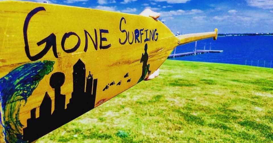Painted surf paddle reading 'Gone Surfing' by waterfront park
