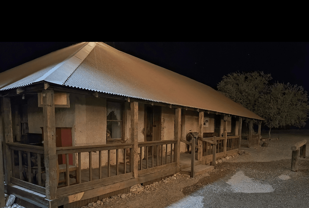 Historic wooden frontier building exterior at night in desert