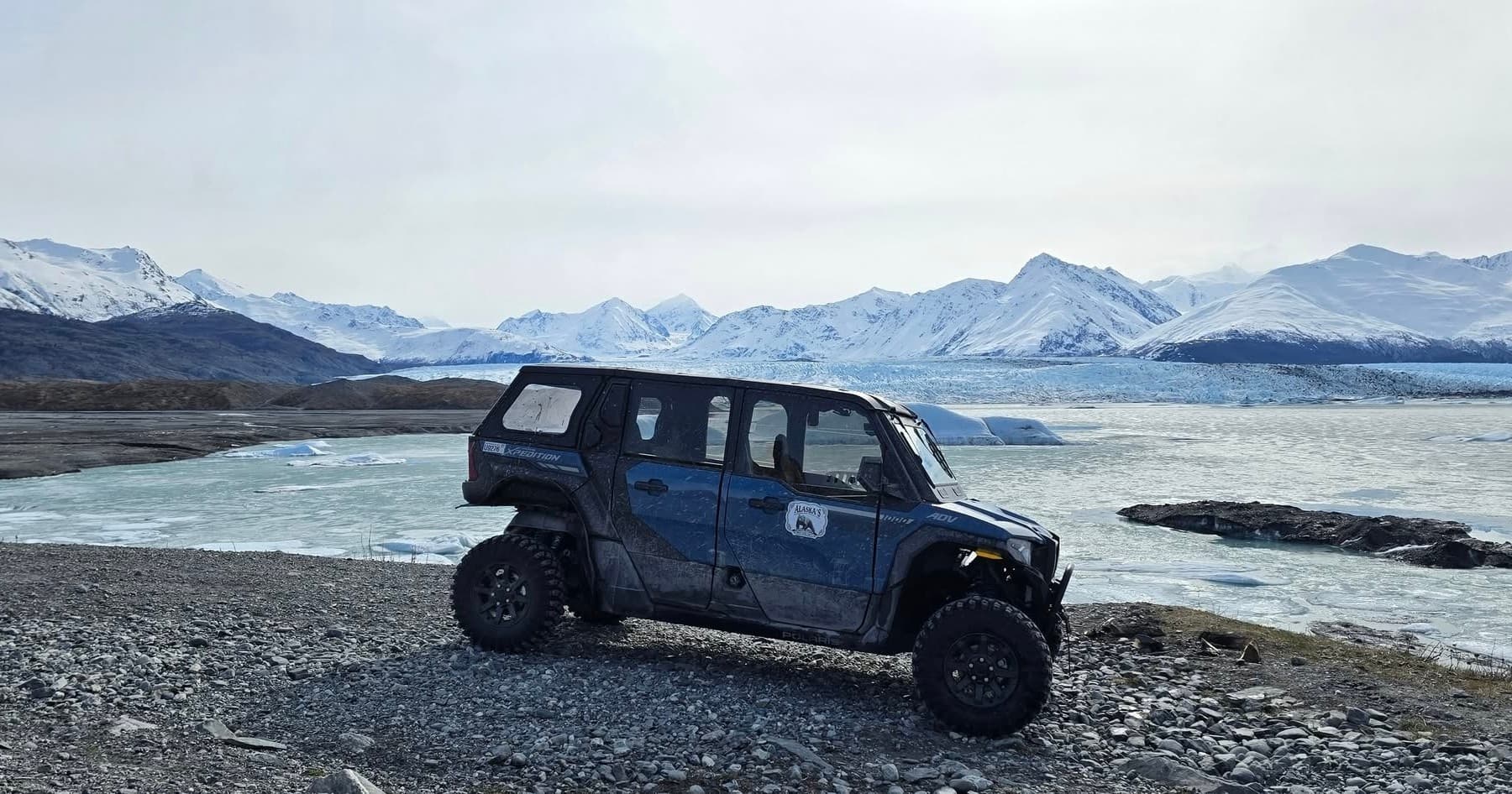 Jeep overlanding near glacial river and mountains in Alaska