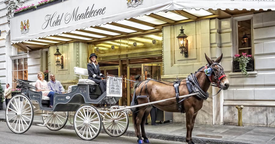Elegantly styled white carriage outside luxury hotel in New Orleans