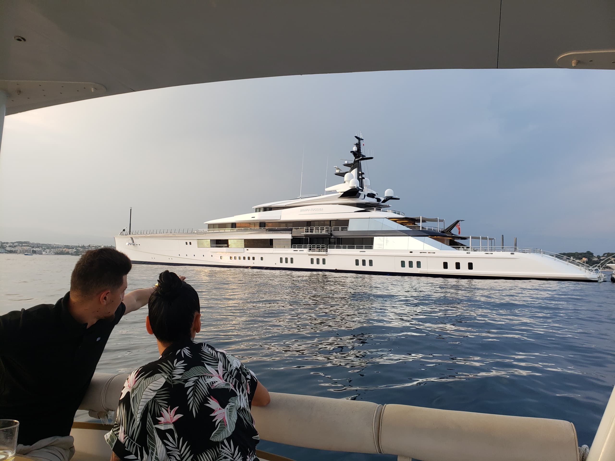Couple watching luxury yacht anchored in peaceful harbor bay