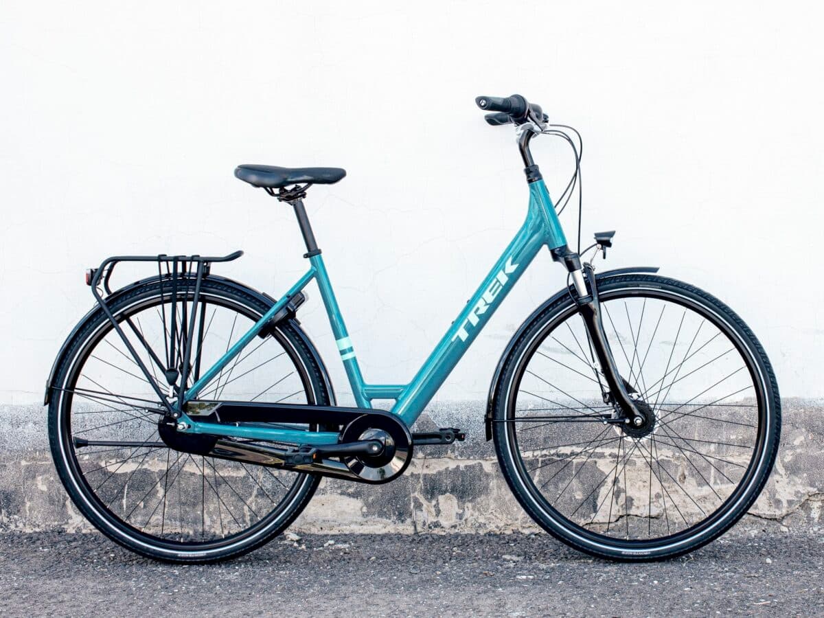Classic city bicycle parked against textured wall on urban street