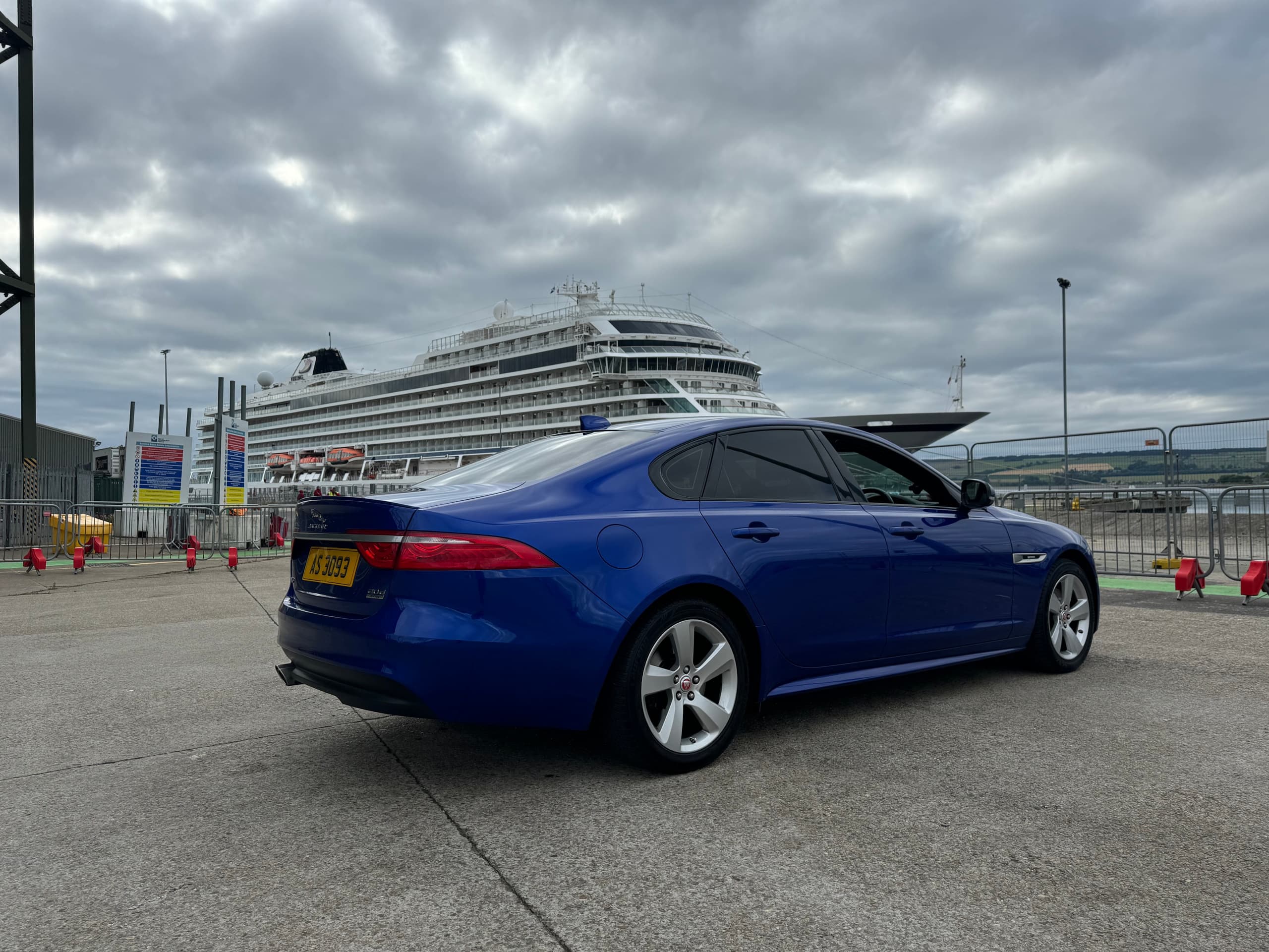 Blue car parked at a cruise terminal by port and pier