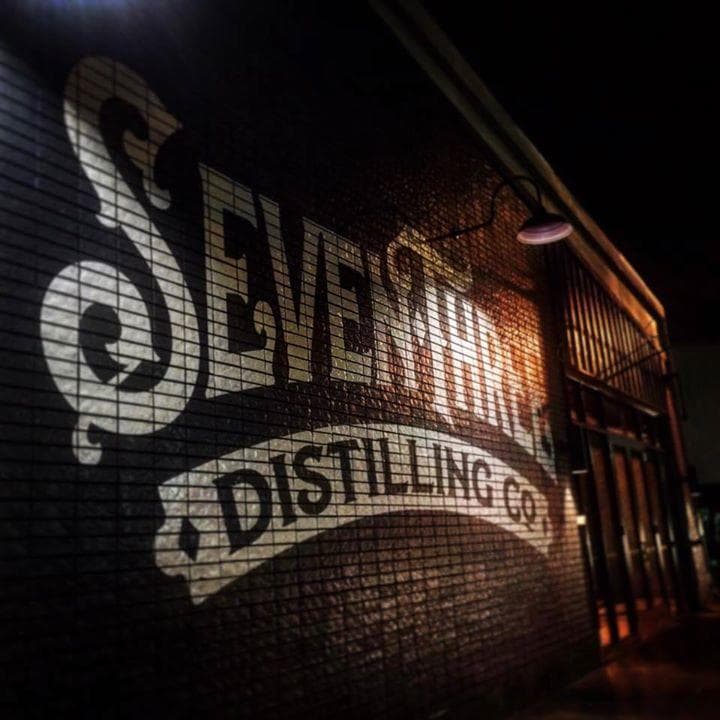 Brick mural exterior reading "Seventh Three" distillery sign