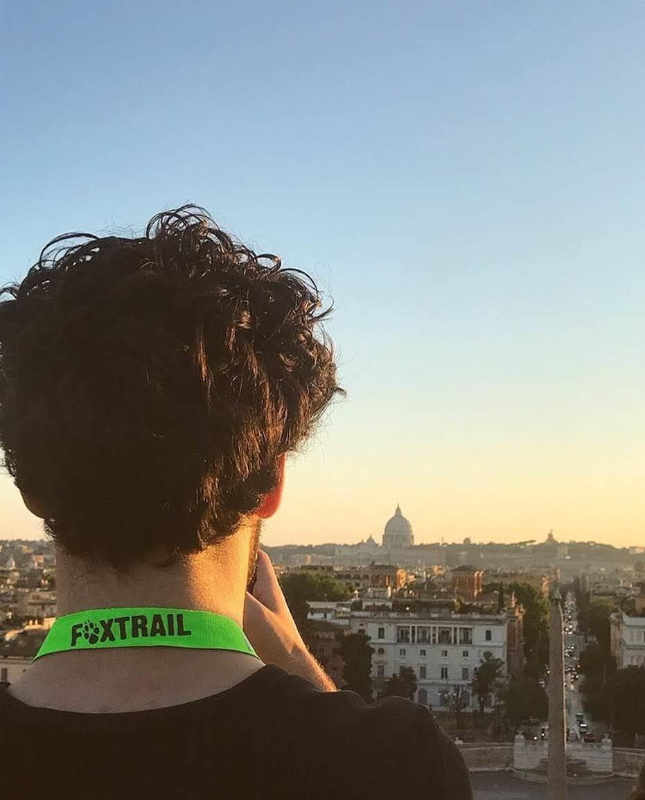 Traveler watching sunset skyline over city rooftops, viewpoint