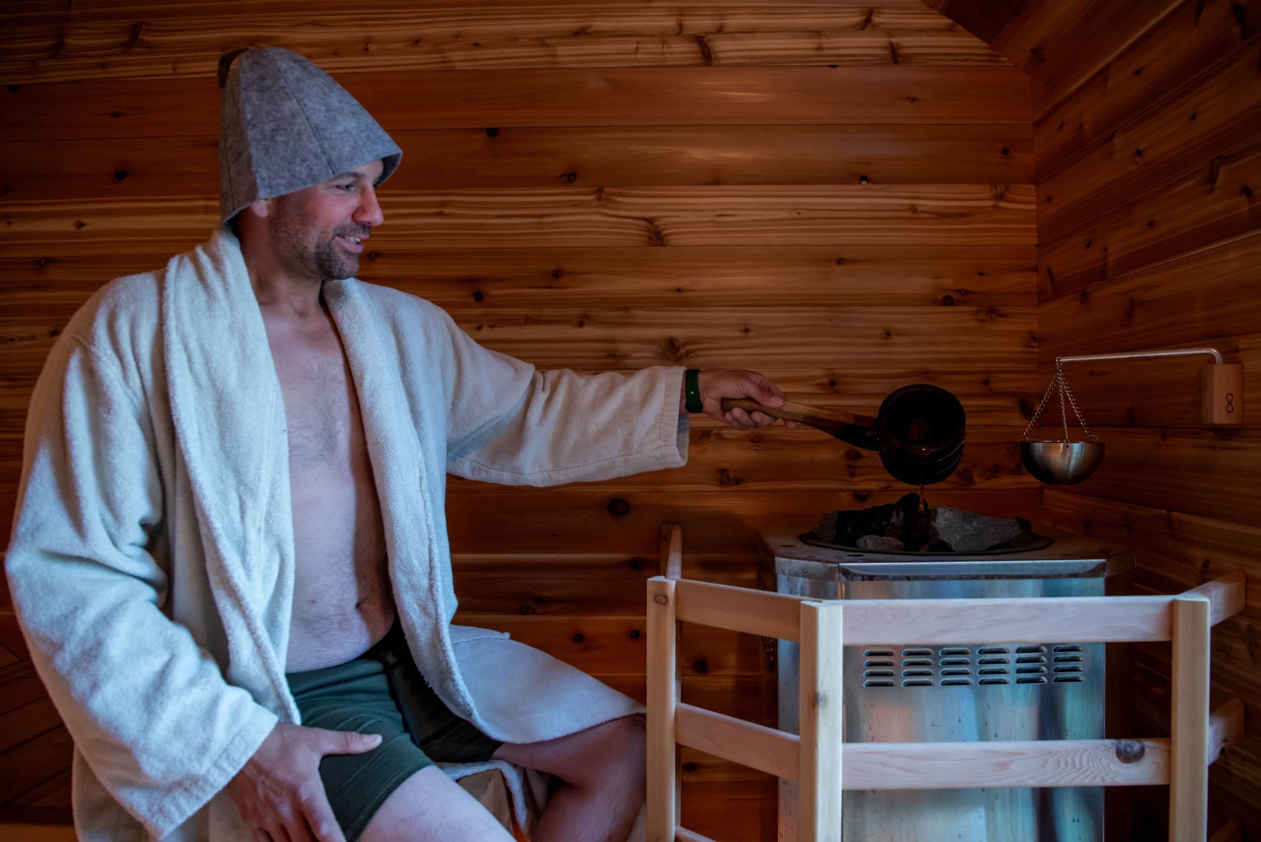 Man enjoying traditional wood-paneled sauna experience in cabin