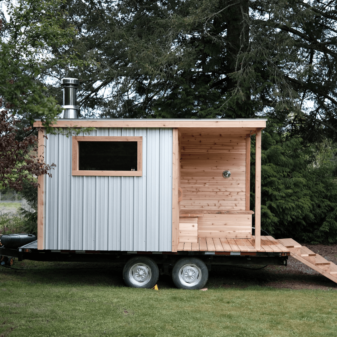 Mobile trailer sauna parked in woodland clearing, outdoor steam