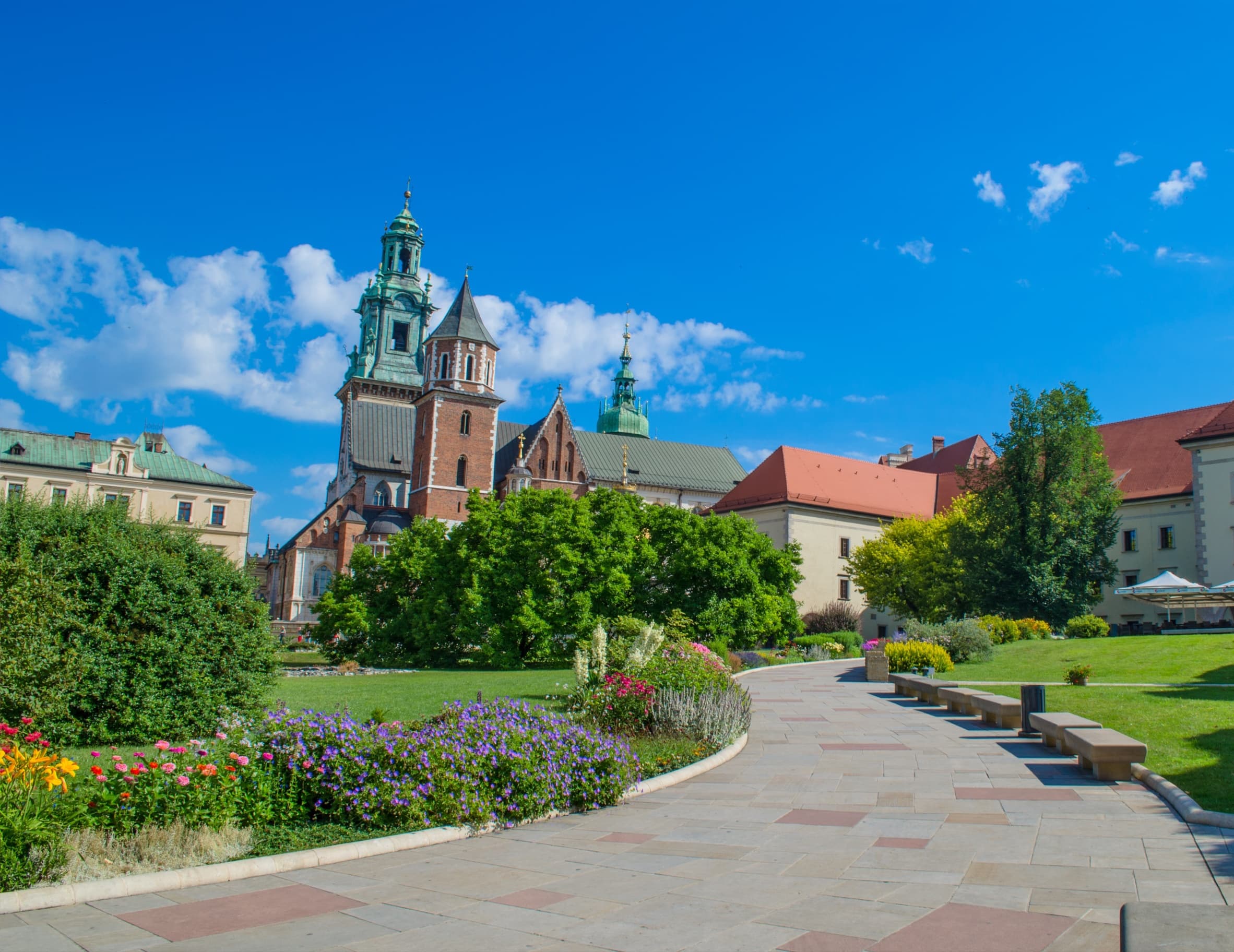 Garden pathway and cathedral towers in Krakow, leisurely sightseeing stroll