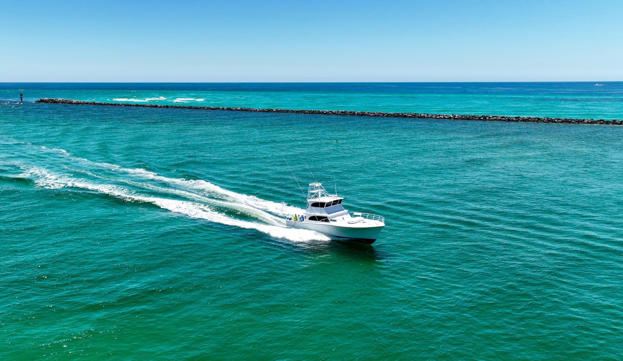 Aerial shot of fast fishing boat leaving wake in turquoise sea