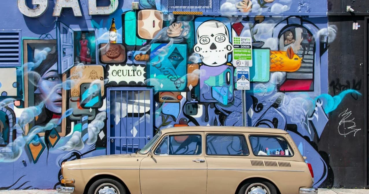 Colorful street mural with vintage station wagon parked along wall