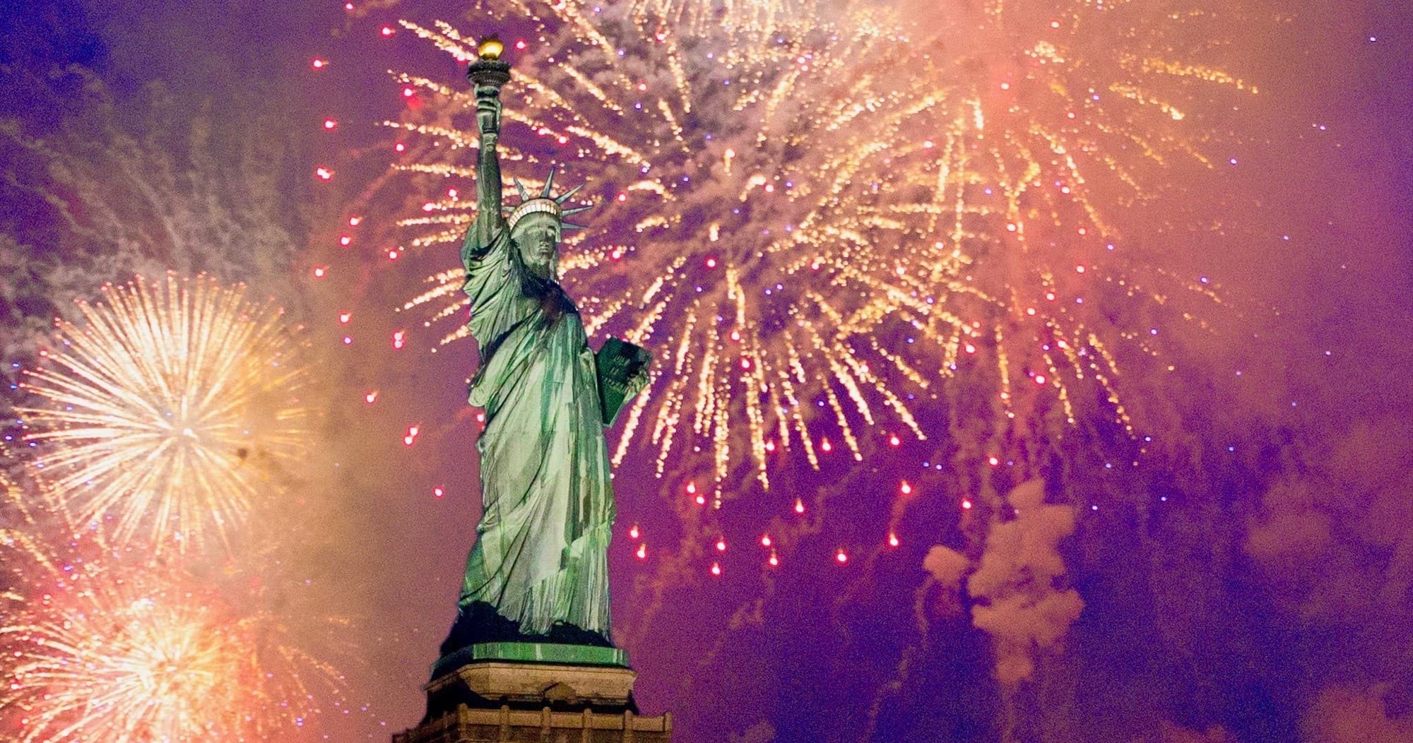 Statue of Liberty with fireworks during festive nighttime harbor cruise