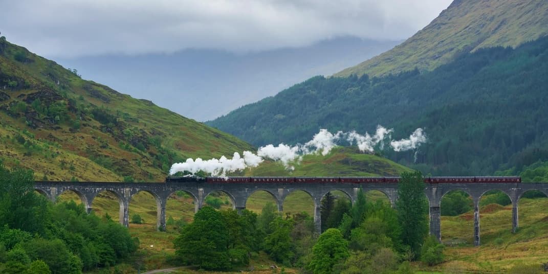 Steam train crossing Glen viaduct in Scottish Highlands