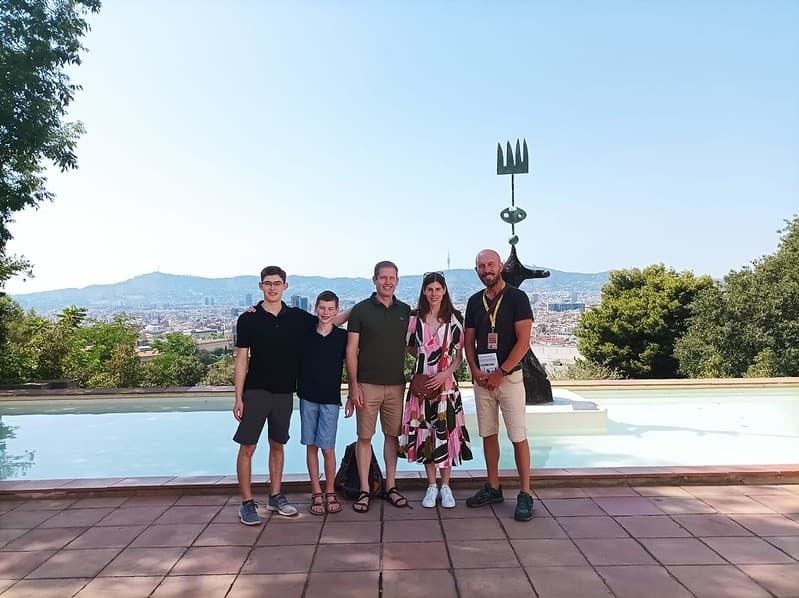Tour group posing at scenic overlook with panoramic city views