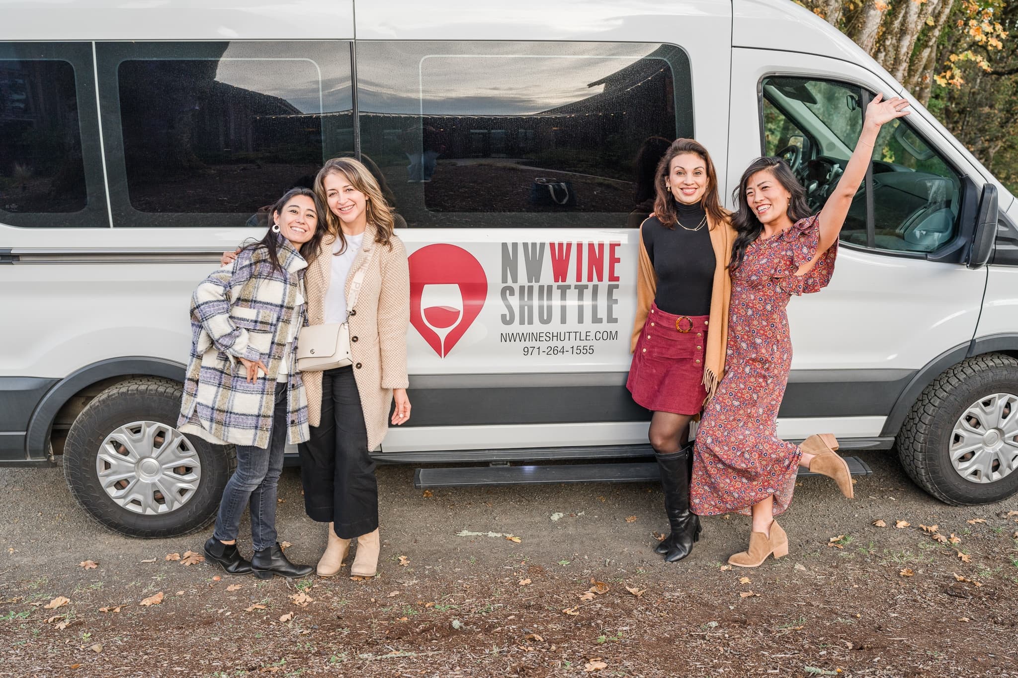 Passengers posing beside wine shuttle van before vineyard tour