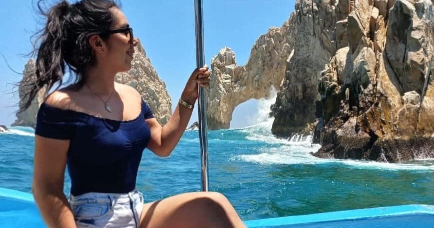 Passenger sightseeing boat near dramatic sea arch at Cabo