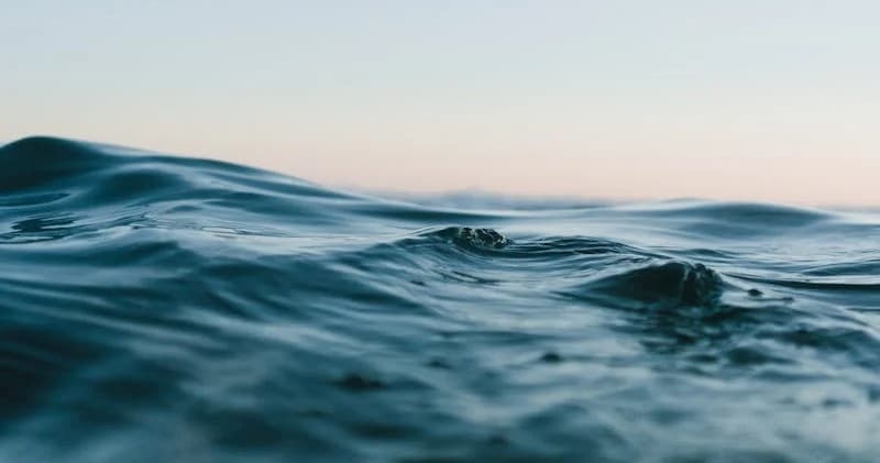 Boat rental ocean waves near coastal horizon during sunset