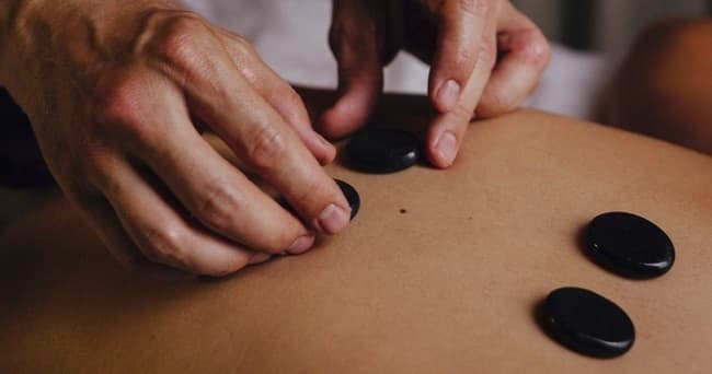 Hot stone massage on back in serene indoor spa treatment