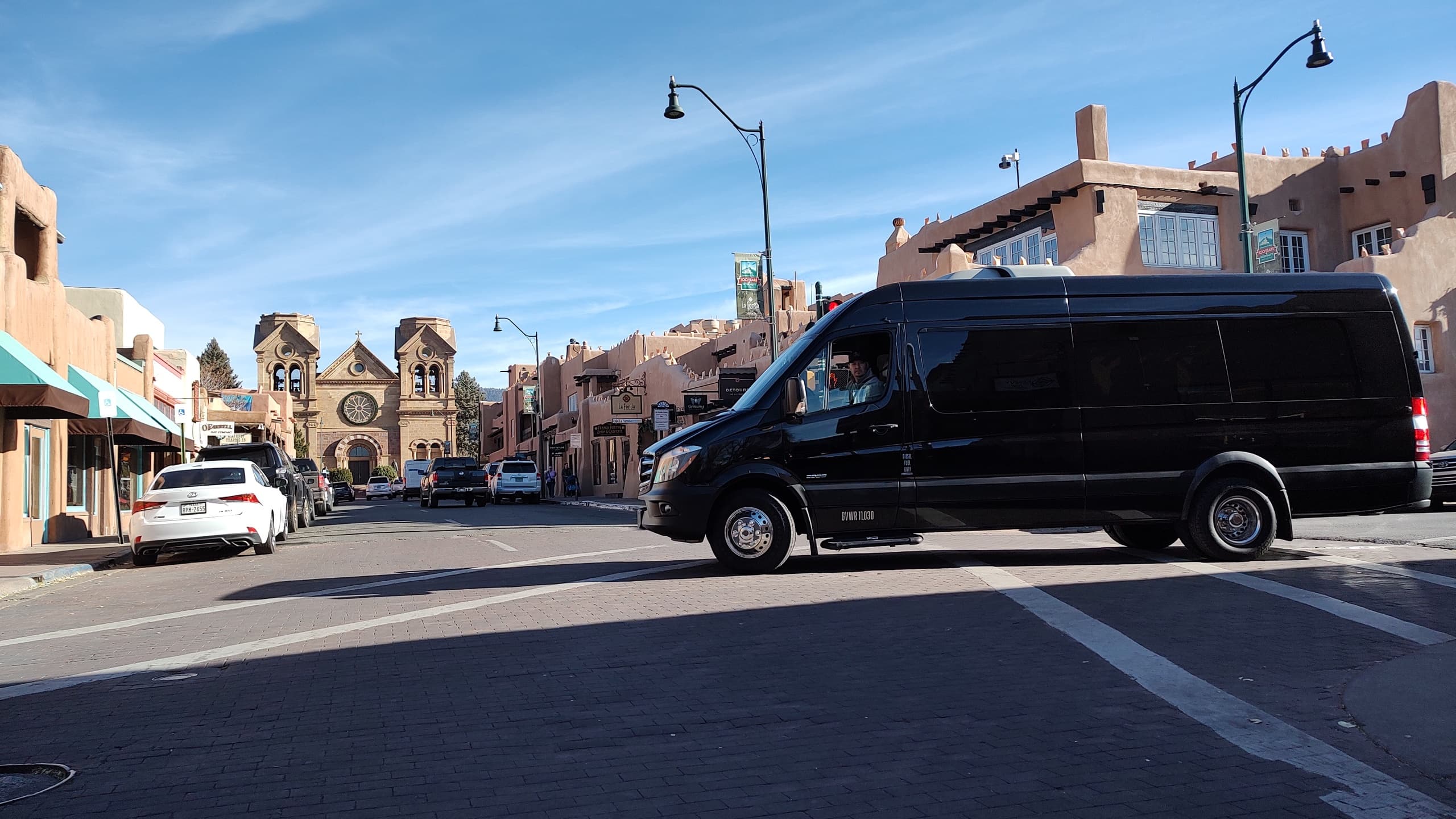 Shuttle van on adobe town street, scenic pueblo town tour