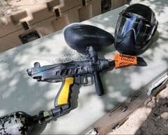 Close-up paintball gun and facemask on table at outdoor park