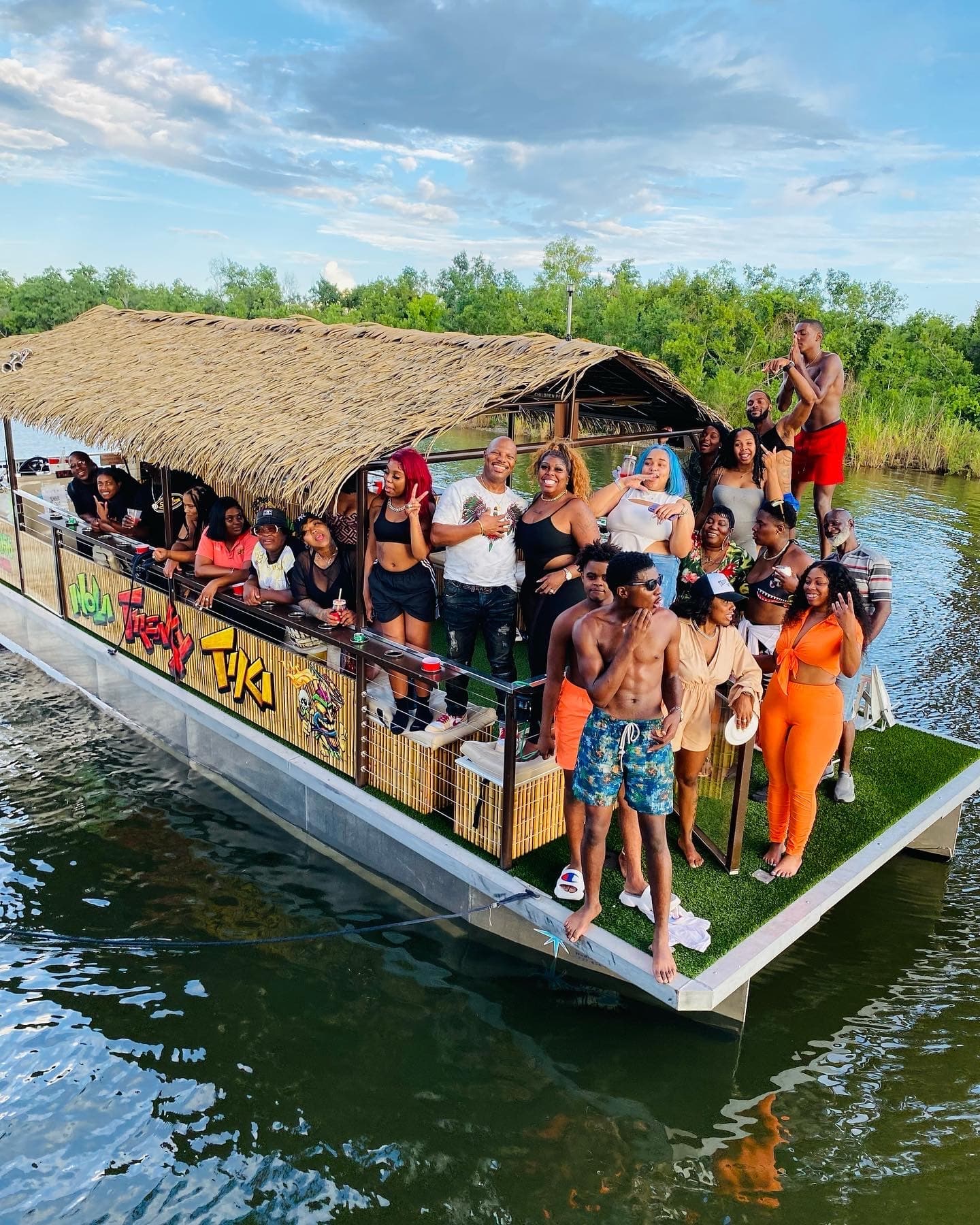 Crowded tiki party boat cruising marshes near New Orleans shoreline