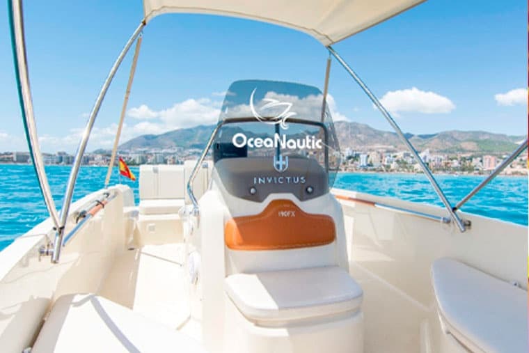 Boat helm view looking out to turquoise sea and coastline