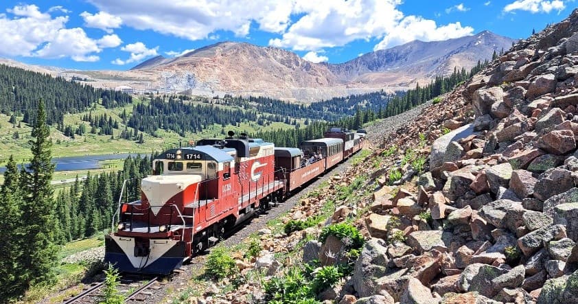 Scenic mountain train crossing alpine valley in summer