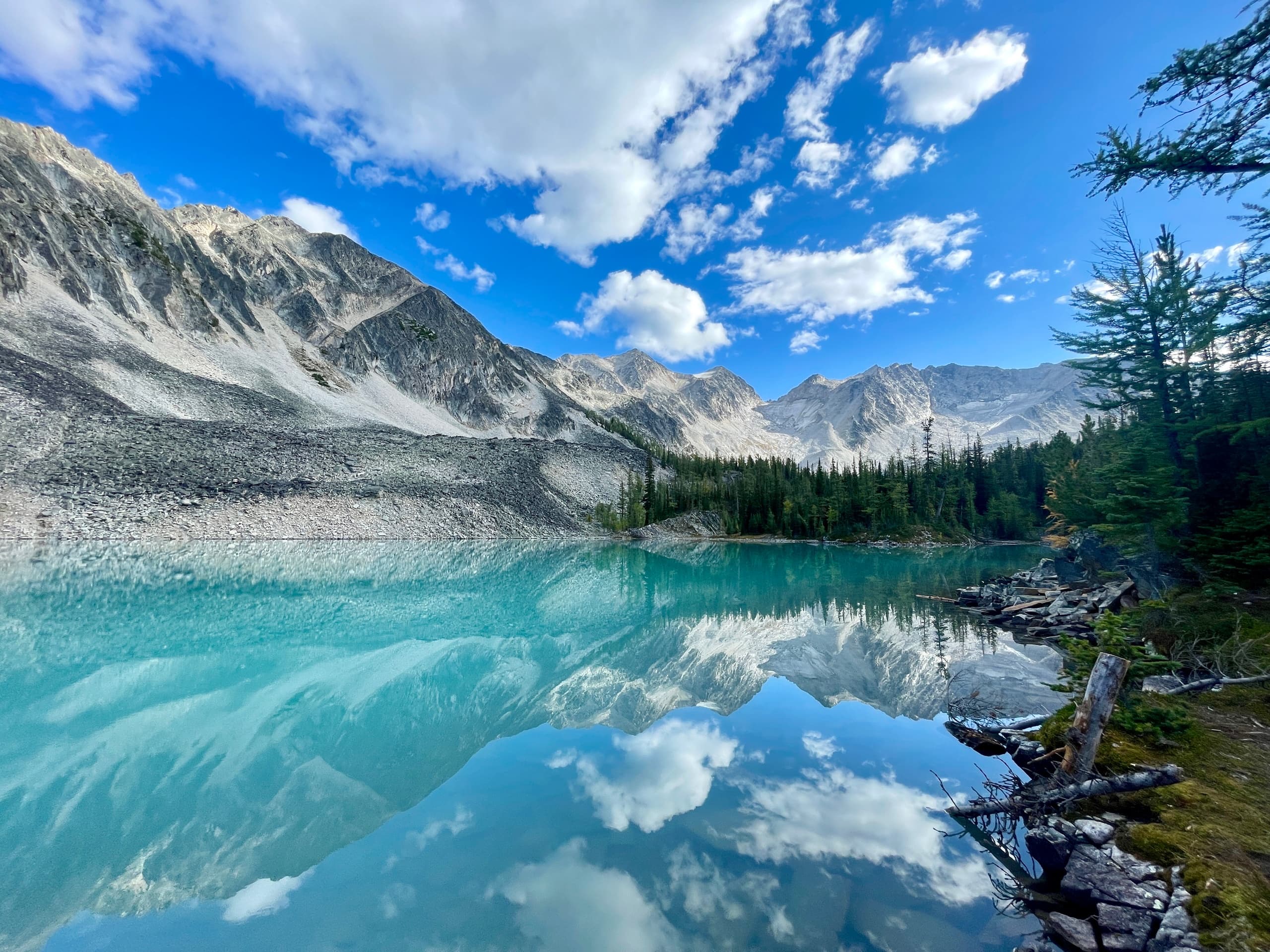 Scenic turquoise alpine lake reflecting mountain peaks and sky