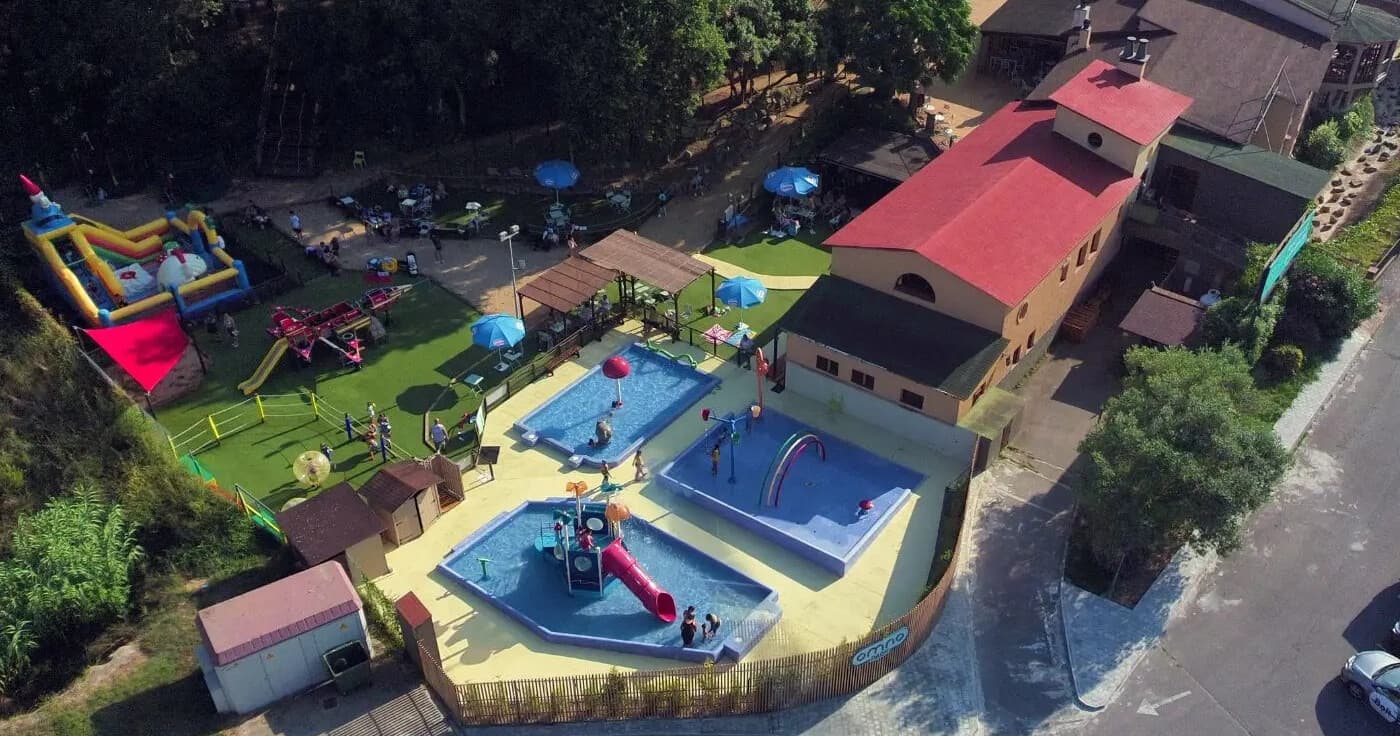 Aerial view of outdoor waterpark with pools, slides, family fun